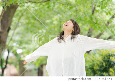 Middle-aged woman refreshing in the park Middle-aged woman refreshing in the park 114981864