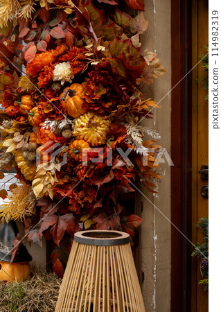 Fall cozy pumpkins in autumn outside. Thanksgiving or Halloween holiday decoration. House entrance in festive seasonal decor. Atmosphere 114982319