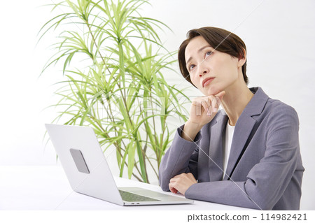 在辦公室思考時在辦公桌前工作的女商人 114982421