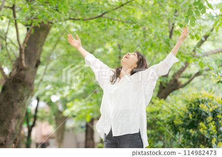 Middle-aged woman stretching in the park Middle-aged woman stretching in the park 114982473