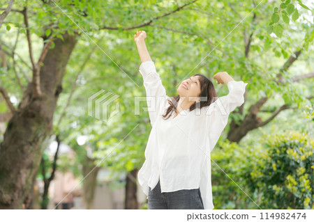 Middle-aged woman stretching in the park Middle-aged woman stretching in the park 114982474