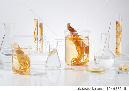 Various types of laboratory glassware with ginseng composition featured on white texture. Advertising photo with frontal shot and blank space in center for presenting product 114982546