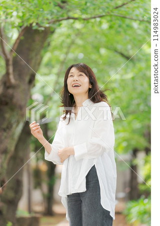 Middle-aged woman smiling in the park 114983024