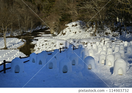 Miniature snow igloos lined up on the riverbed at the mouth of the Yunishigawa River in Yunishigawa Onsen, Nikko City 114983732