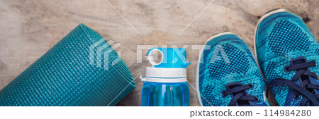 BANNER, LONG FORMAT Everything for sports turquoise, blue shades on a wooden background. Yoga mat, sport shoes sportswear and bottle of water. Concept healthy lifestyle, sport and diet. Sport BANNER, LONG FORMAT Everything for sports turquoise, blue shades on a wooden background. Yoga mat, sport shoes sportswear and bottle of water. Concept healthy lifestyle, sport and diet. Sport 114984280