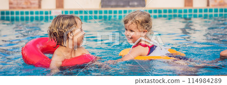two little kids playing in the swimming pool BANNER, LONG FORMAT two little kids playing in the swimming pool BANNER, LONG FORMAT 114984289