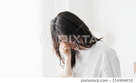 Woman holding tired eyes Woman holding tired eyes 114984658