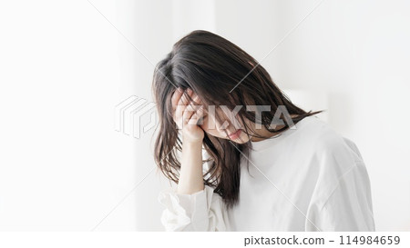 A woman suffering from a headache 114984659