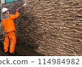 A male craftsman high-pressure washing the wall of a house 114984982