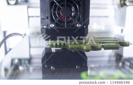 3D printer working close-up. 3D printer prints model from molten plastic close-up. 3D printer printing object. Additive progressive high-tech technology. New modern prototyping technologies. 3D printer working close-up. 3D printer prints model from molten plastic close-up. 3D printer printing object. Additive progressive high-tech technology. New modern prototyping technologies. 114986396