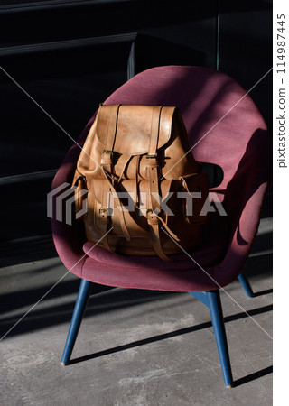 Brown leather backpack on chair, close up. Brown leather backpack on chair, close up. 114987445