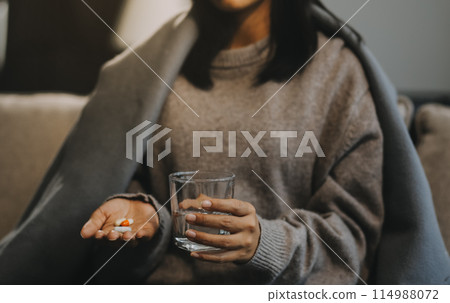 Upset woman frustrated by problem with work or relationships, sitting on couch, embracing knees, covered face in hand, feeling despair and anxiety, loneliness, having psychological trouble 114988072