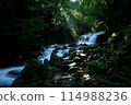 A mountain stream with a waterfall bathed in the morning light 114988236