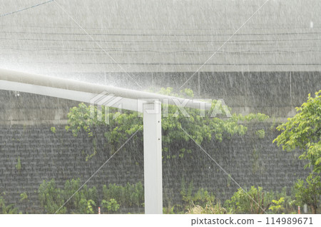 Heavy rain pounding the carport roof 114989671