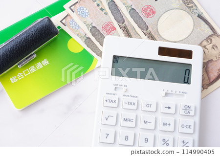 A bank passbook, a personal seal, a 10,000 yen note, and a calculator on a table A bank passbook, a personal seal, a 10,000 yen note, and a calculator on a table 114990405