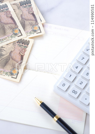 銀行存摺、10,000日元鈔票和計算機放在桌上打開 銀行存摺、10,000日元鈔票和計算機放在桌上打開 114990581