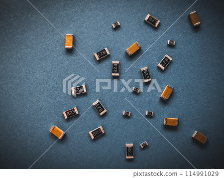 Electronic components, many ceramic capacitors and chip resistors on PCB background 114991029