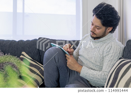 A man seriously thinking with his notebook open A man seriously thinking with his notebook open 114991444