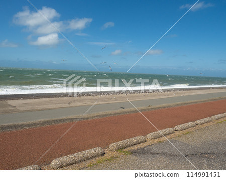 Zeeland, Netherlands - August 2nd 2023: Cycling path at the waterfront close to Westkapelle. Zeeland, Netherlands - August 2nd 2023: Cycling path at the waterfront close to Westkapelle. 114991451