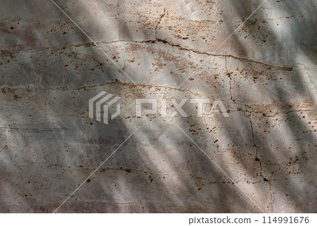 The sun is shining through the old brick cracked wall. 114991676