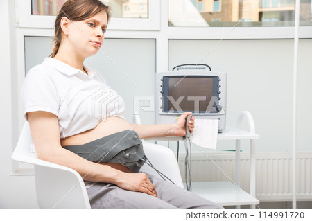 Pregnant Woman Undergoing Cardiotocography CTG Monitoring 114991720