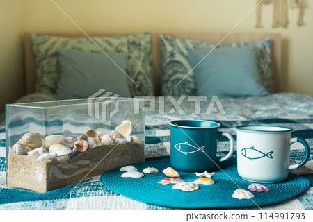 Cups of tea in a nautical style on the bed. Good morning. Cups of tea in a nautical style on the bed. Good morning. 114991793