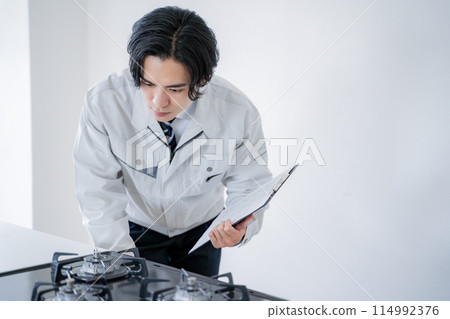 Male worker inspecting a gas stove 114992376