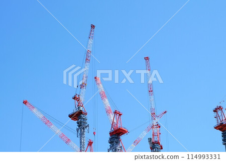 High-rise building under construction, construction site crane and blue sky 114993331