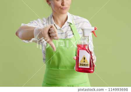 Unhappy woman showing thumbs down isolated on green Unhappy woman showing thumbs down isolated on green 114993698