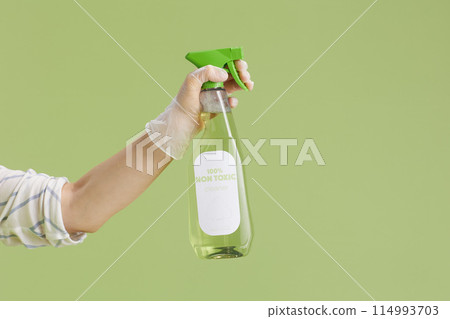 Modern housewife in green apron and rubber gloves on green Modern housewife in green apron and rubber gloves on green 114993703