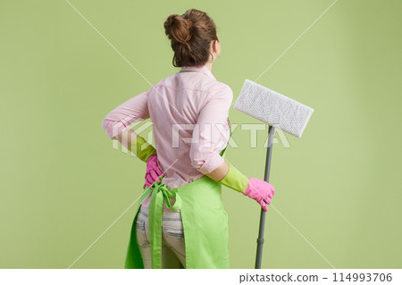woman in green apron and rubber gloves against green 114993706