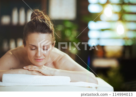 relaxed modern woman in spa salon laying on massage table relaxed modern woman in spa salon laying on massage table 114994013