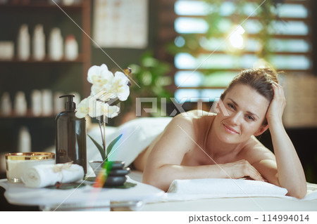 relaxed modern woman in spa salon laying on massage table relaxed modern woman in spa salon laying on massage table 114994014