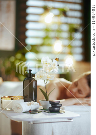 Relaxed woman in massage cabinet laying on massage table 114994015