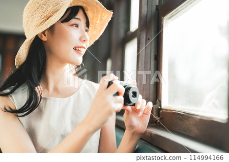 Woman taking a photo from the car window Woman taking a photo from the car window 114994166