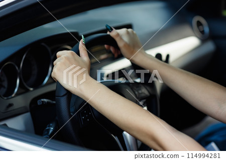 Young woman driver hands close up hold steering wheel car. Young woman driver hands close up hold steering wheel car. 114994281