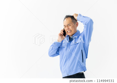 Man in work clothes, smartphone, talking, troubled 114994531