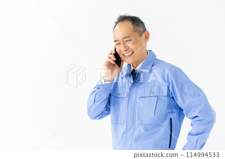 Man in work clothes, smartphone, talking, troubled 114994533