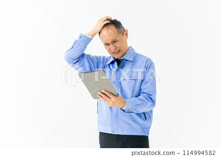 Man in work clothes, tablet, troubled 114994582