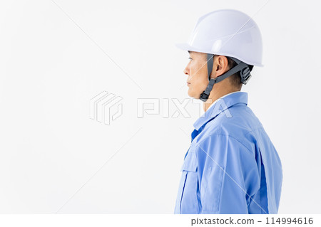 Man in work clothes, helmet, sideways Man in work clothes, helmet, sideways 114994616