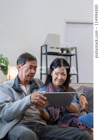 Senior couple using tablet at home. Concept of technology, companionship, and relaxation 114994880