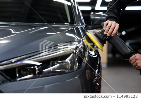 A master polishes the surface of a car body. A master polishes the surface of a car body. 114995128