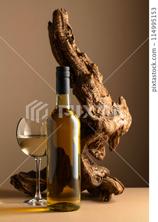White wine and old snag on a beige background. 114995153