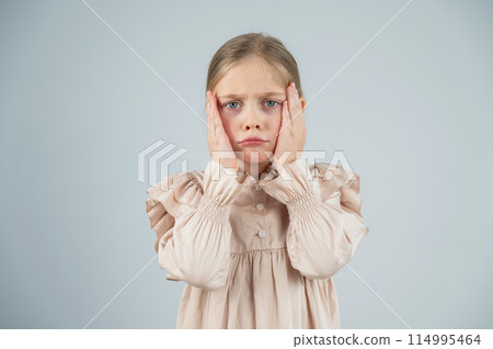 Portrait of a dissatisfied Caucasian girl on a white background. Portrait of a dissatisfied Caucasian girl on a white background. 114995464