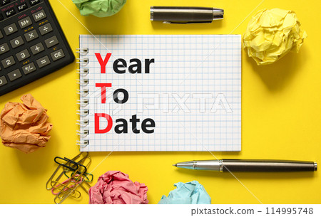 YTD year to date symbol. Concept words YTD year to date on beautiful white note. Beautiful yellow background. Black calculator. Business YTD year to date concept. Copy space. 114995748