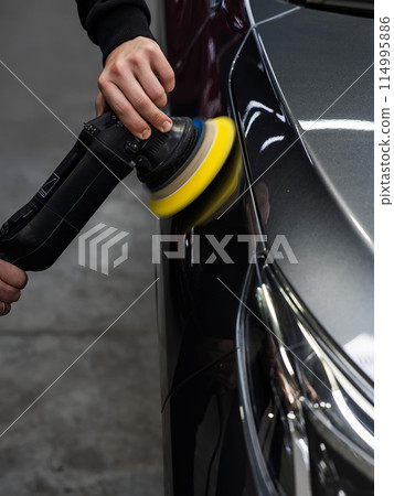 A master polishes the surface of a car body. A master polishes the surface of a car body. 114995886