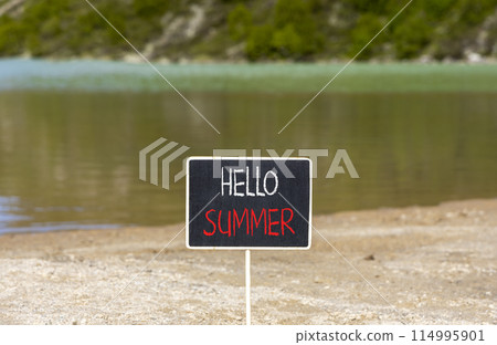 Hello summer symbol. Concept words Hello summer on beautiful yellow blackboard. Beautiful mountain lake sand beach background. Business lifestyle Hello summer concept. Copy space. 114995901