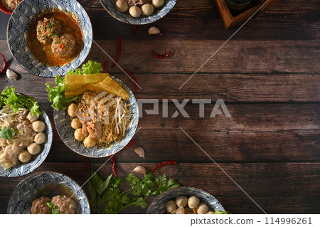 Top view of various spicy Thai noodles, scalded meatball and vegetables on wooden table 114996261