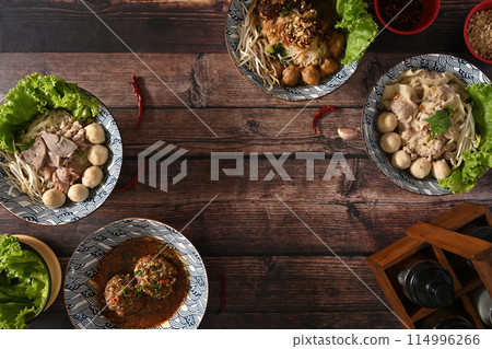 Tasty spicy Thai noodles, scalded meatball and condiment set for seasoning on wooden table Tasty spicy Thai noodles, scalded meatball and condiment set for seasoning on wooden table 114996266