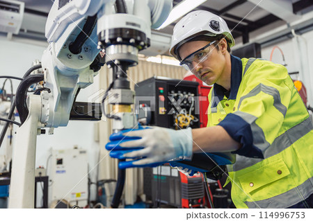 Engineer young man university student learn to control operate industry robot welding arm in robotics engineers lab classroom in polytechnic education. 114996753